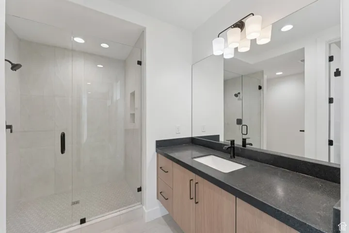 Full bathroom featuring vanity, a stall shower, recessed lighting, and tile patterned flooring