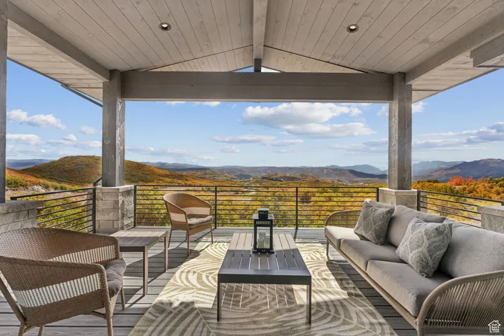 Wooden deck featuring outdoor lounge area, a mountain view, and a patio