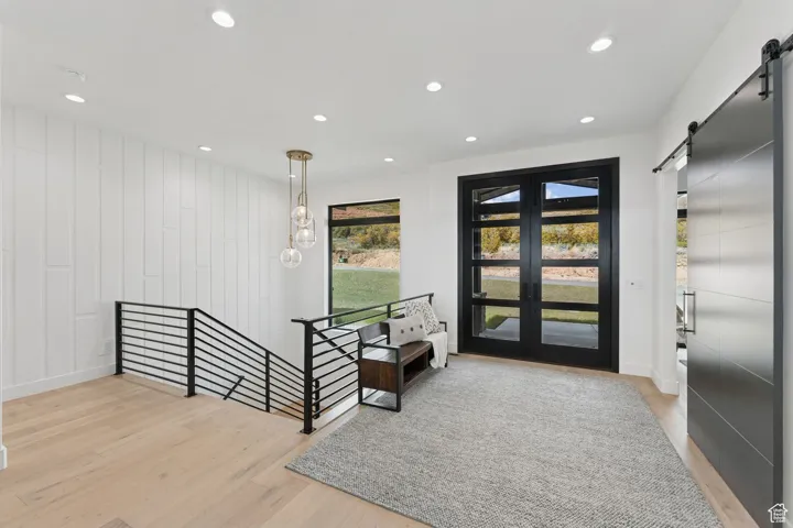 Entrance foyer featuring a barn door, light wood-style flooring, and recessed lighting