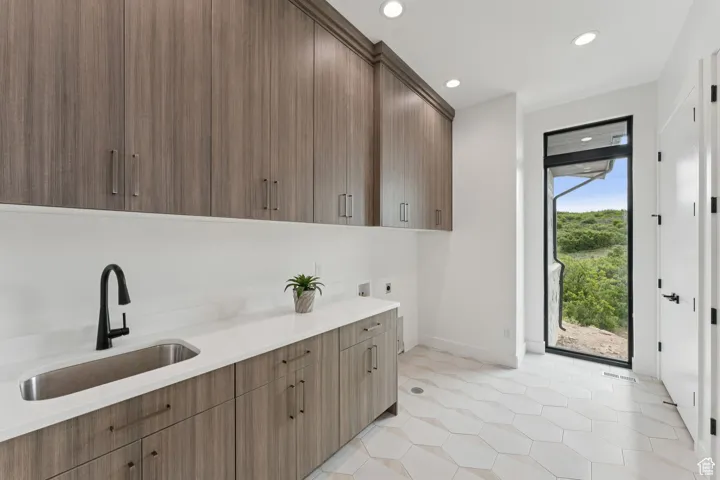 Kitchen featuring light countertops, recessed lighting, light tile patterned floors, and modern cabinets
