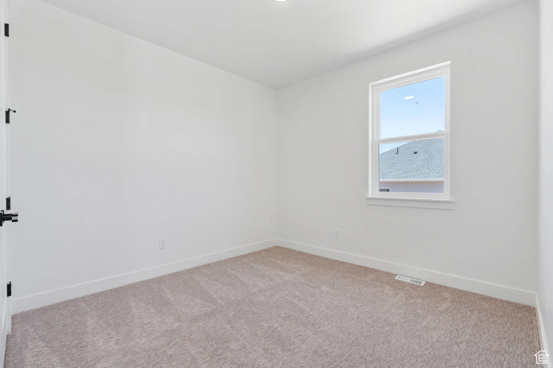 Spare room with light colored carpet and baseboards