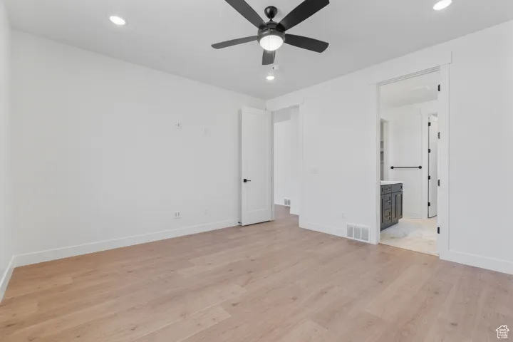 Empty room featuring light wood finished floors, a ceiling fan, and recessed lighting