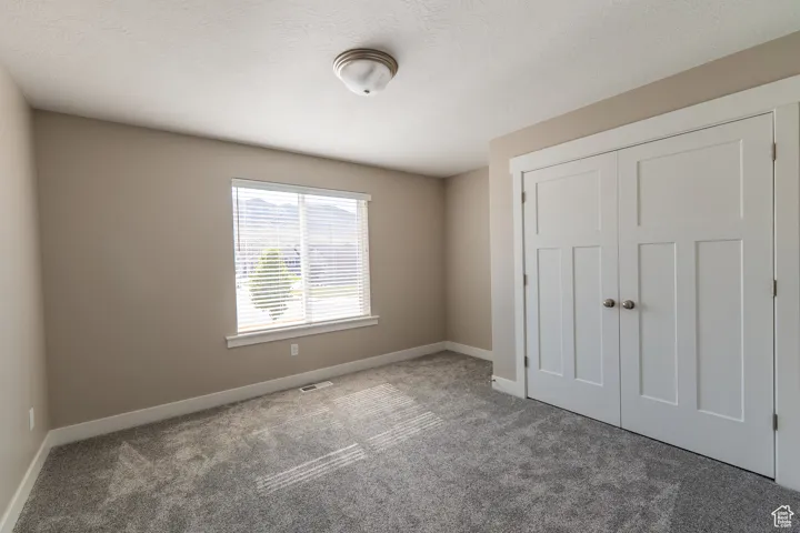 Unfurnished bedroom with carpet flooring and a closet