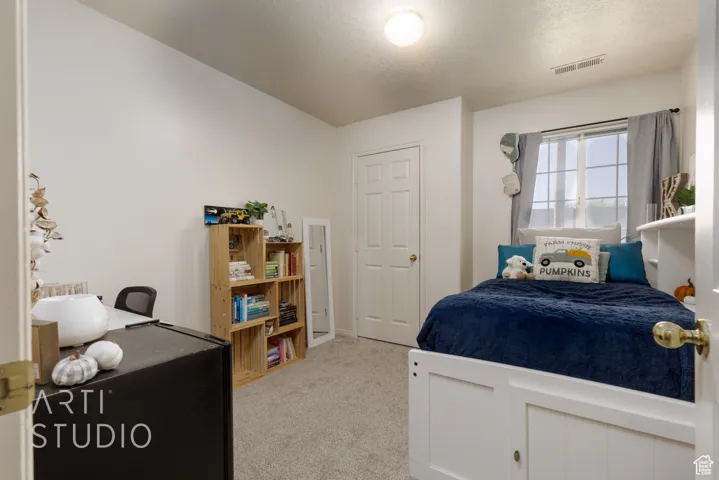 Carpeted bedroom featuring a textured ceiling