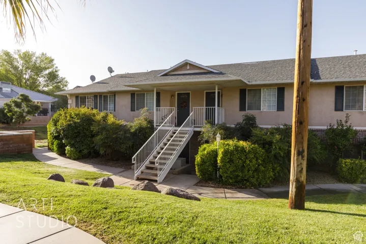 Ranch-style home featuring stucco siding, a front lawn, covered porch, and stairs