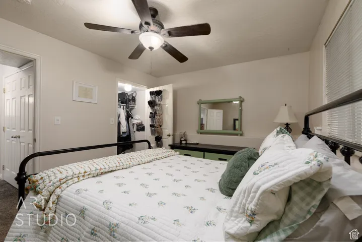 Bedroom featuring carpet floors, a spacious closet, a closet, and a ceiling fan