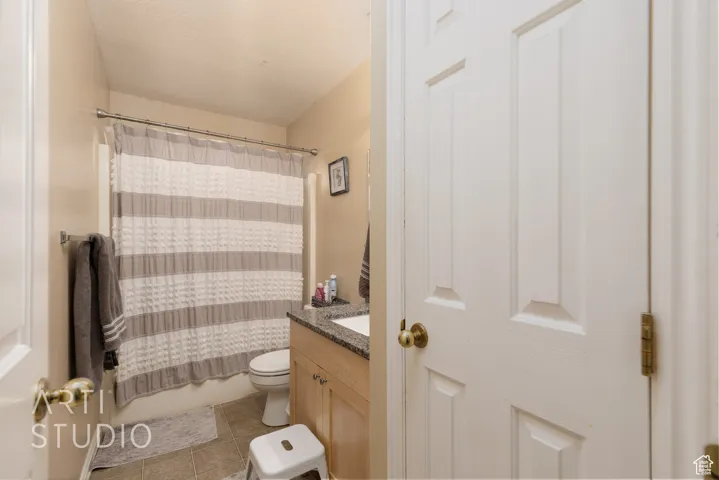 Full bath featuring vanity, tile patterned flooring, and shower / bathtub combination with curtain