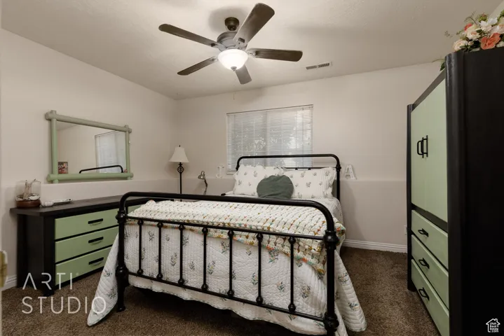 Bedroom featuring dark carpet and a ceiling fan