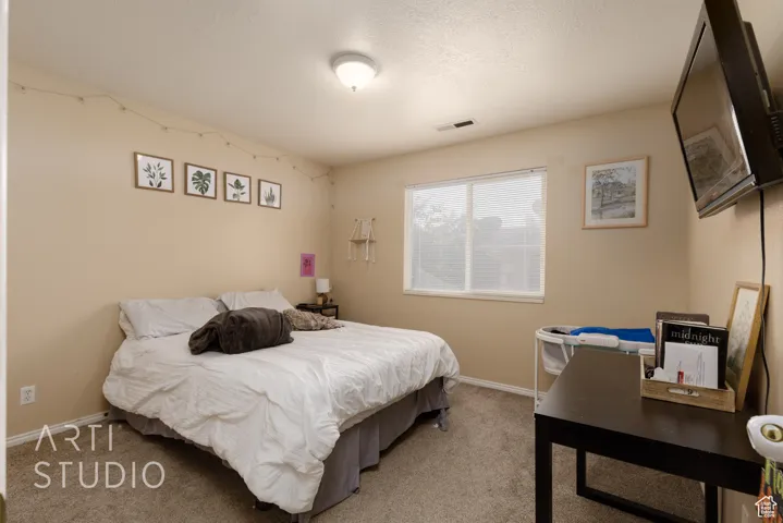 Bedroom with light carpet and baseboards