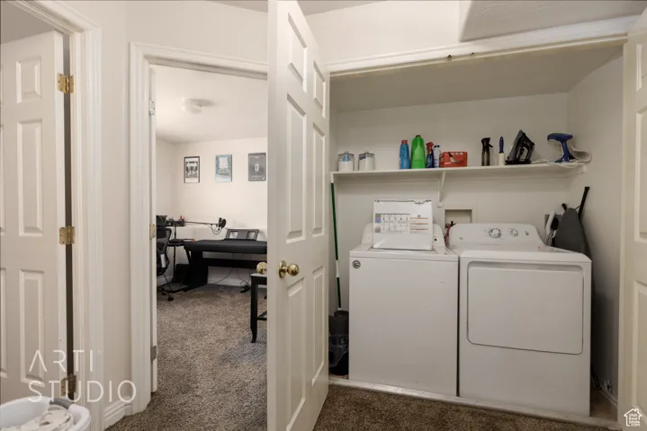 Washroom featuring independent washer and dryer and dark colored carpet