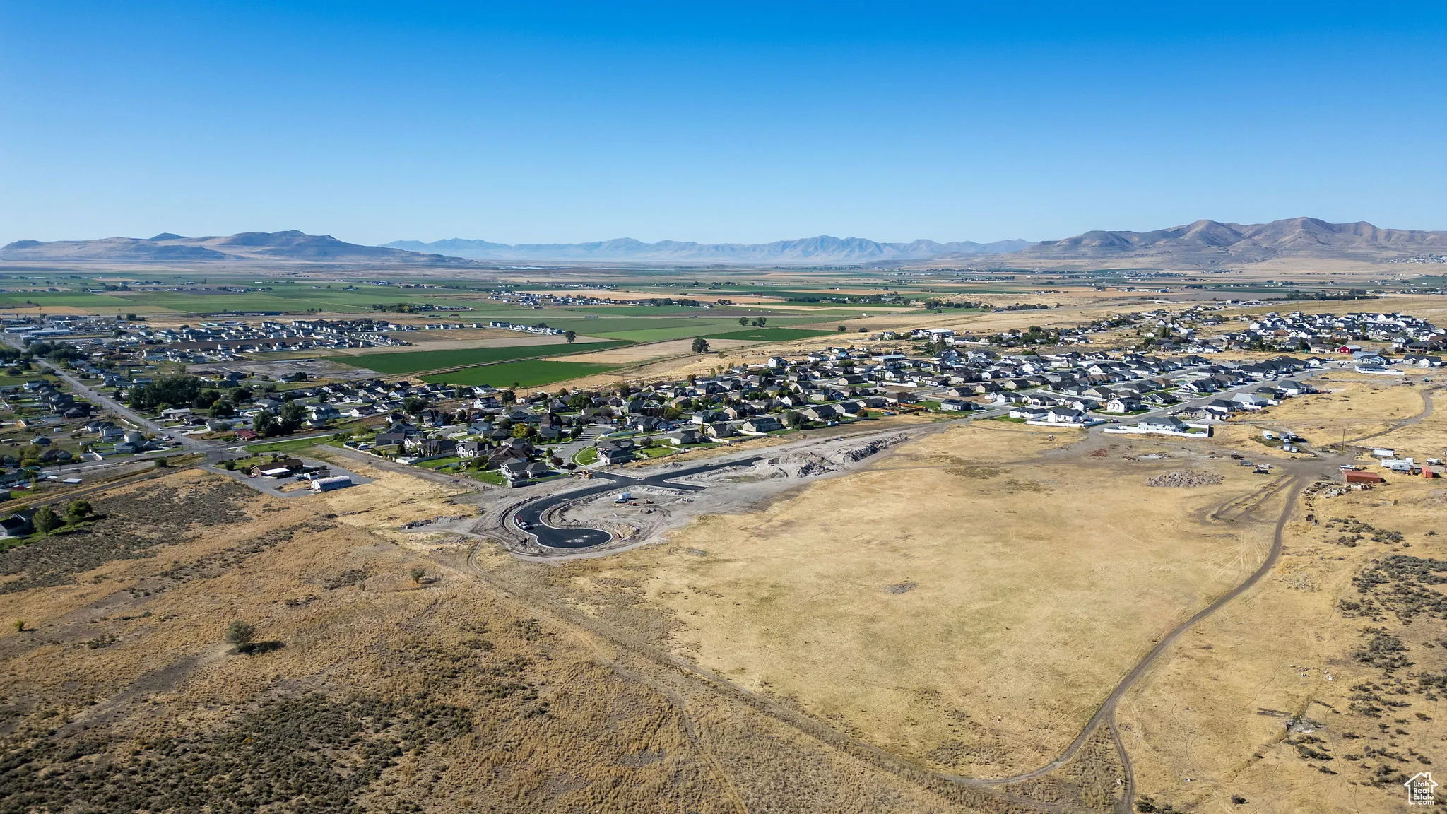 Overview of rural landscape with a mountainous background and nearby suburban area