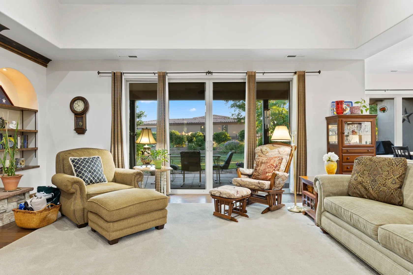 Recessed lighting illuminates a spacious carpeted interior with white walls and a tray ceiling