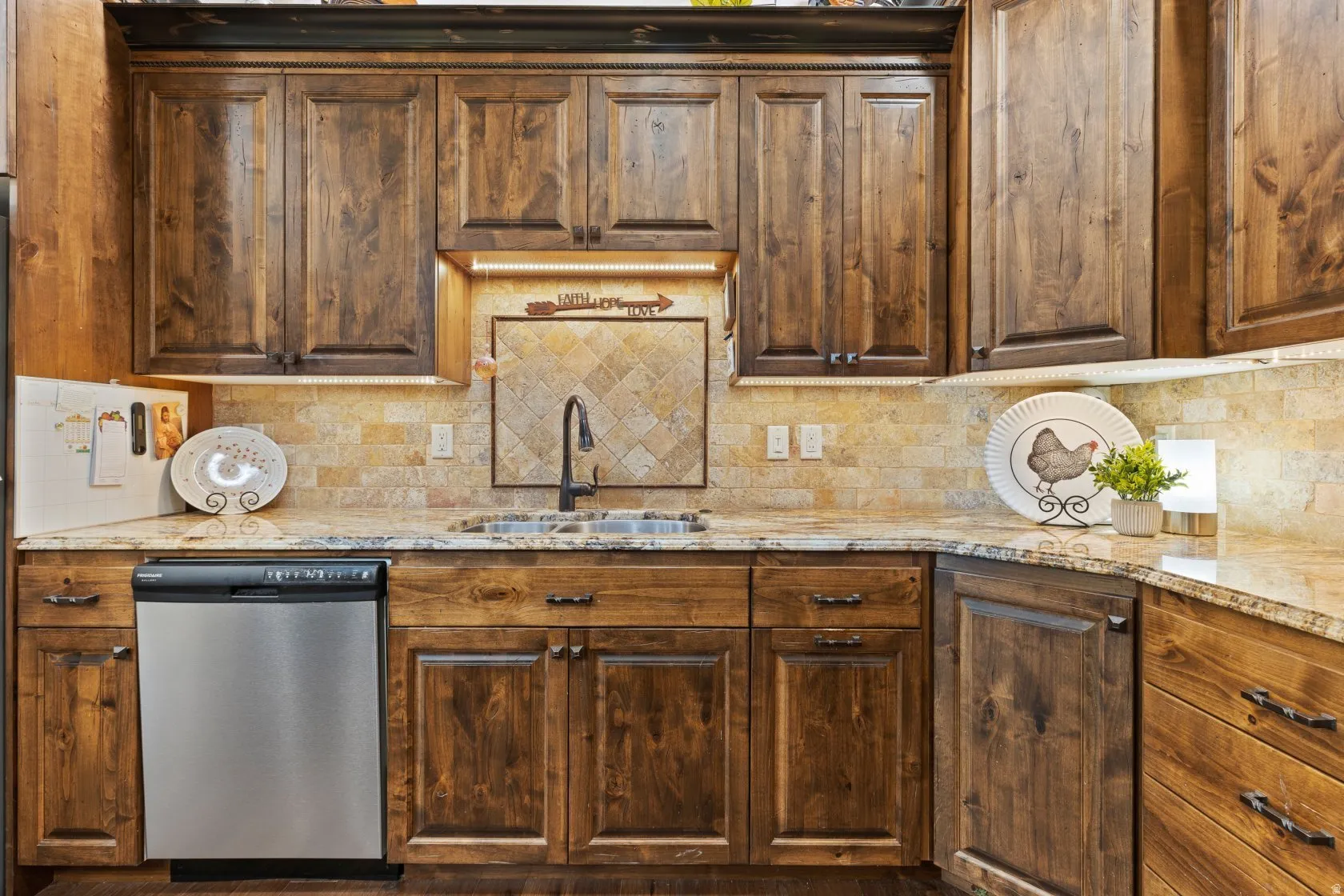 Kitchen featuring dark wood cabinetry, granite countertops, and a tiled backsplash