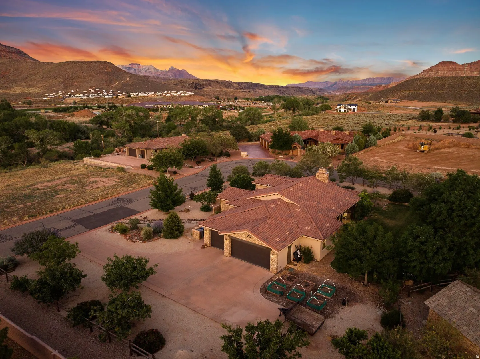 Spanish Colonial-style residence featuring a terracotta-tiled roof, stone facade, and a two-car garage