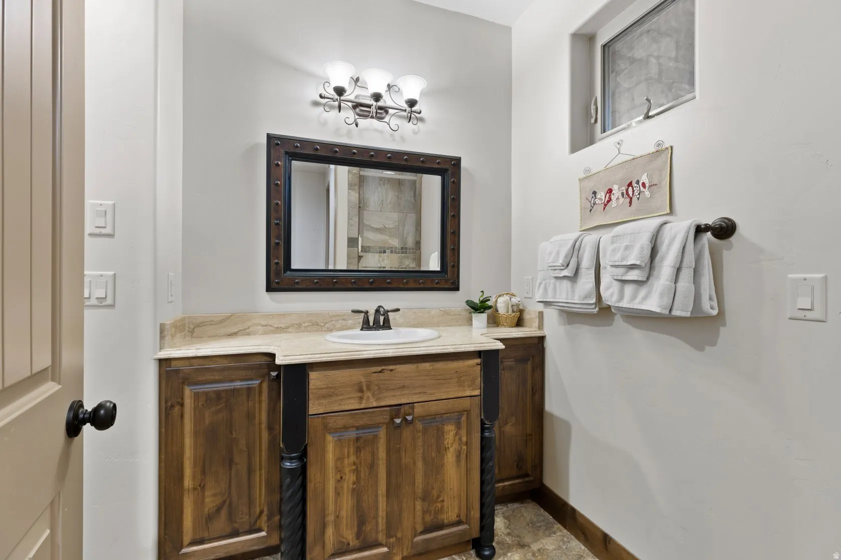 Vanity with natural wood cabinetry and a light-colored countertop