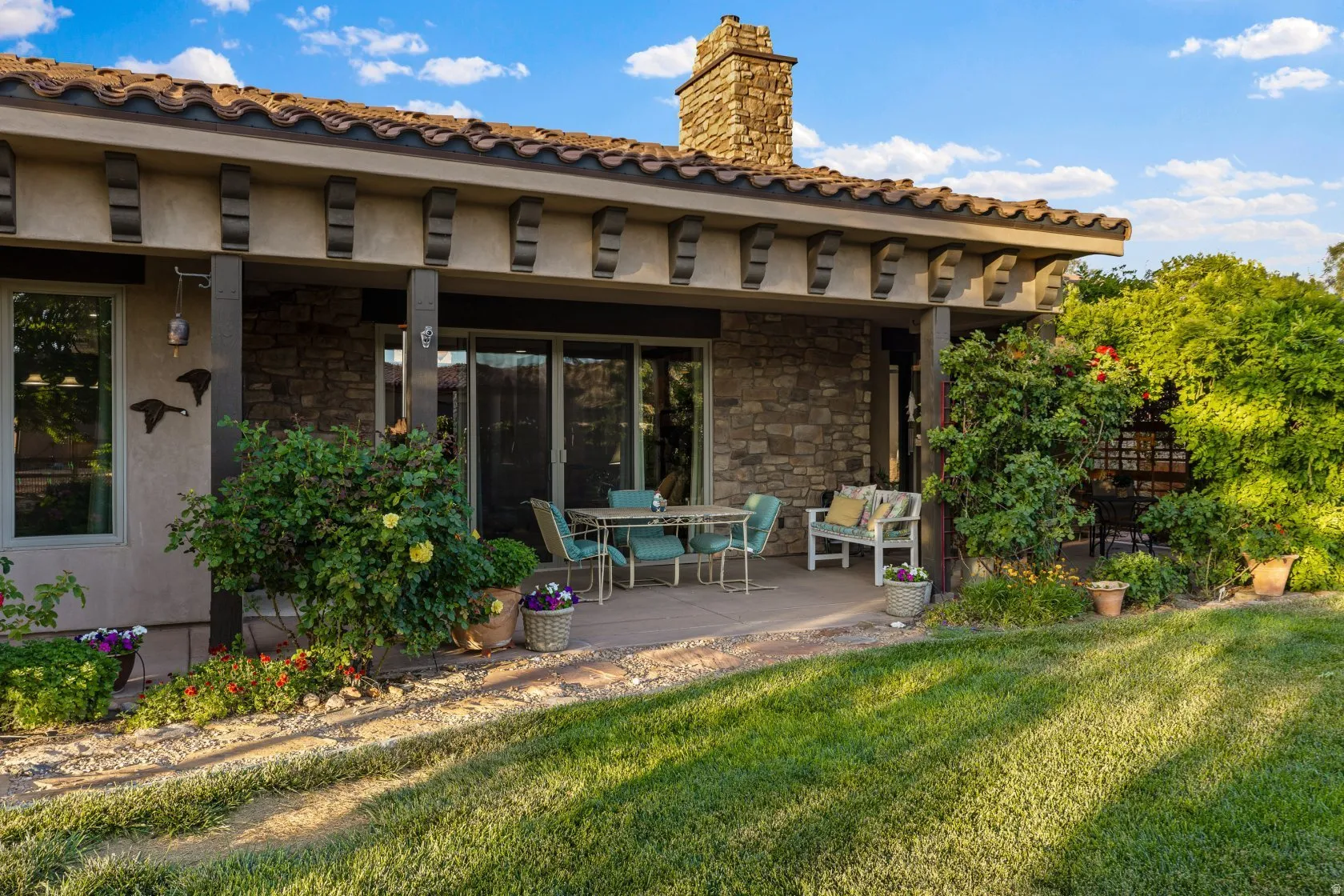 Covered patio featuring a stone facade and a tiled roofline