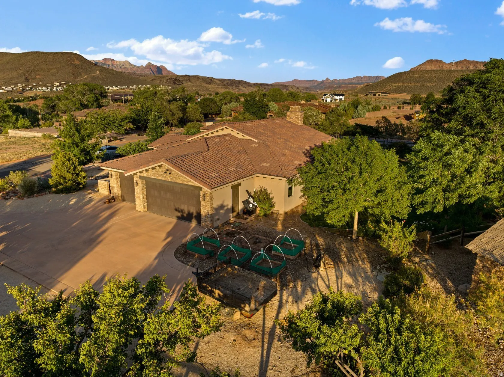 Southwestern style residence featuring a tile roof, stone accents, attached two-car garage, and a concrete driveway