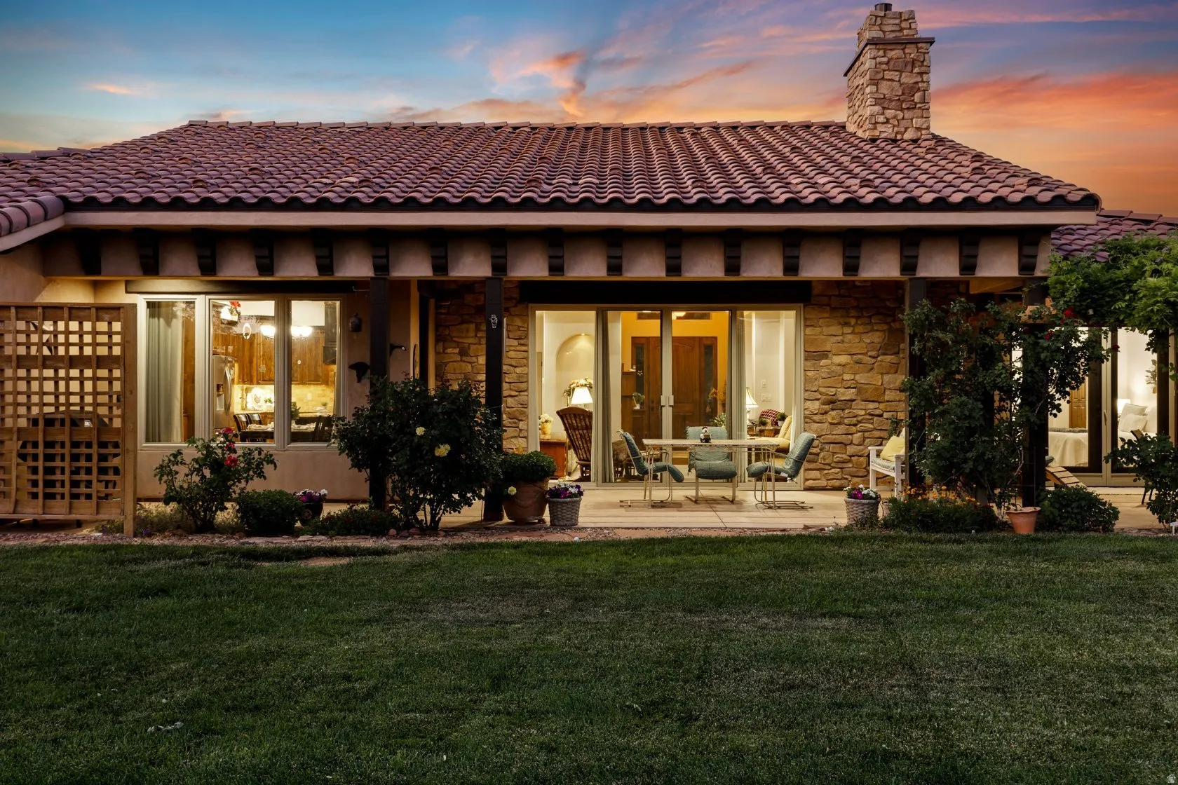 Expansive rear patio featuring stone exterior accents and a tile roof