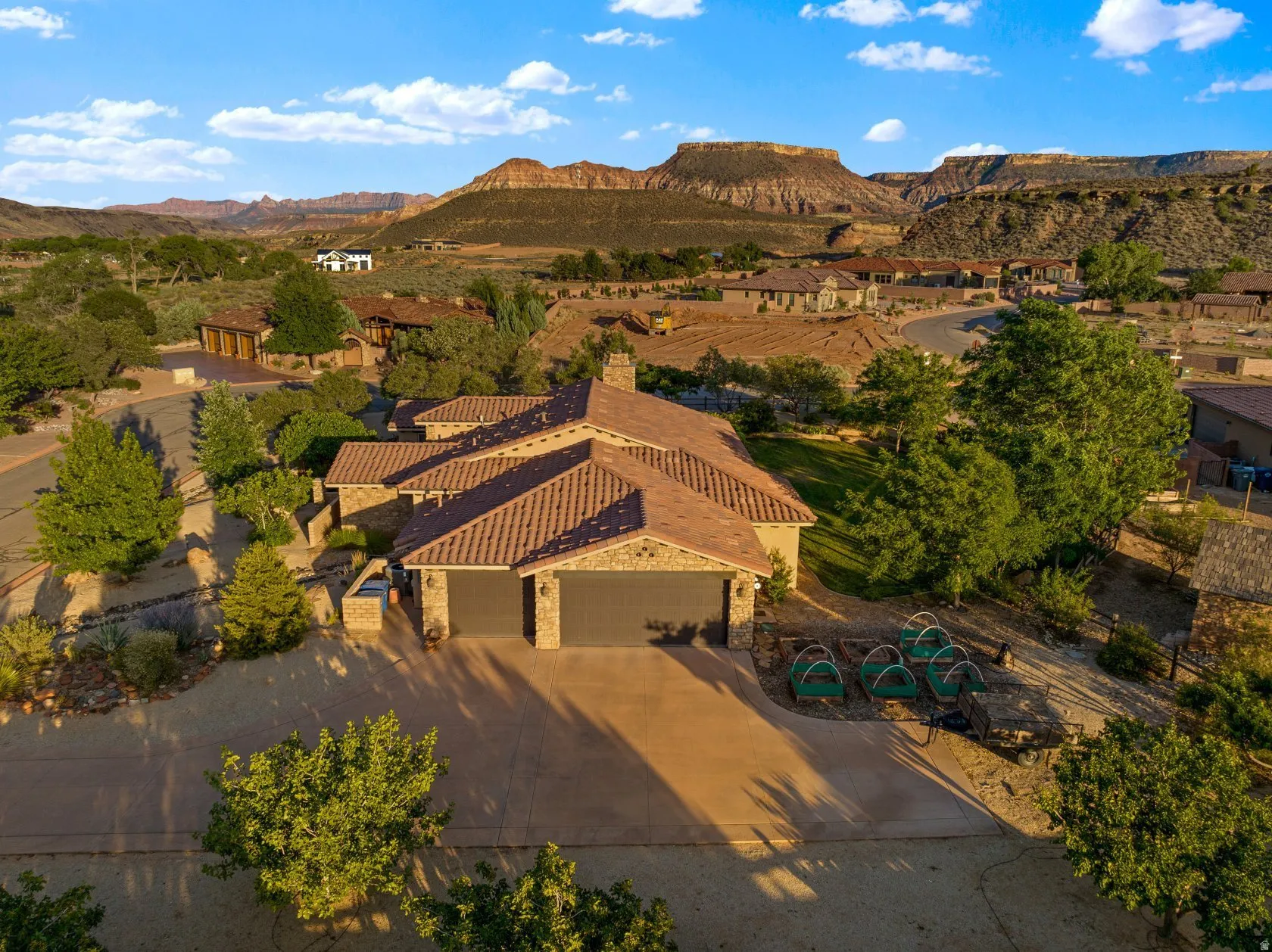 Mediterranean-style residence featuring a tile roof, stone accents, and a two-car garage
