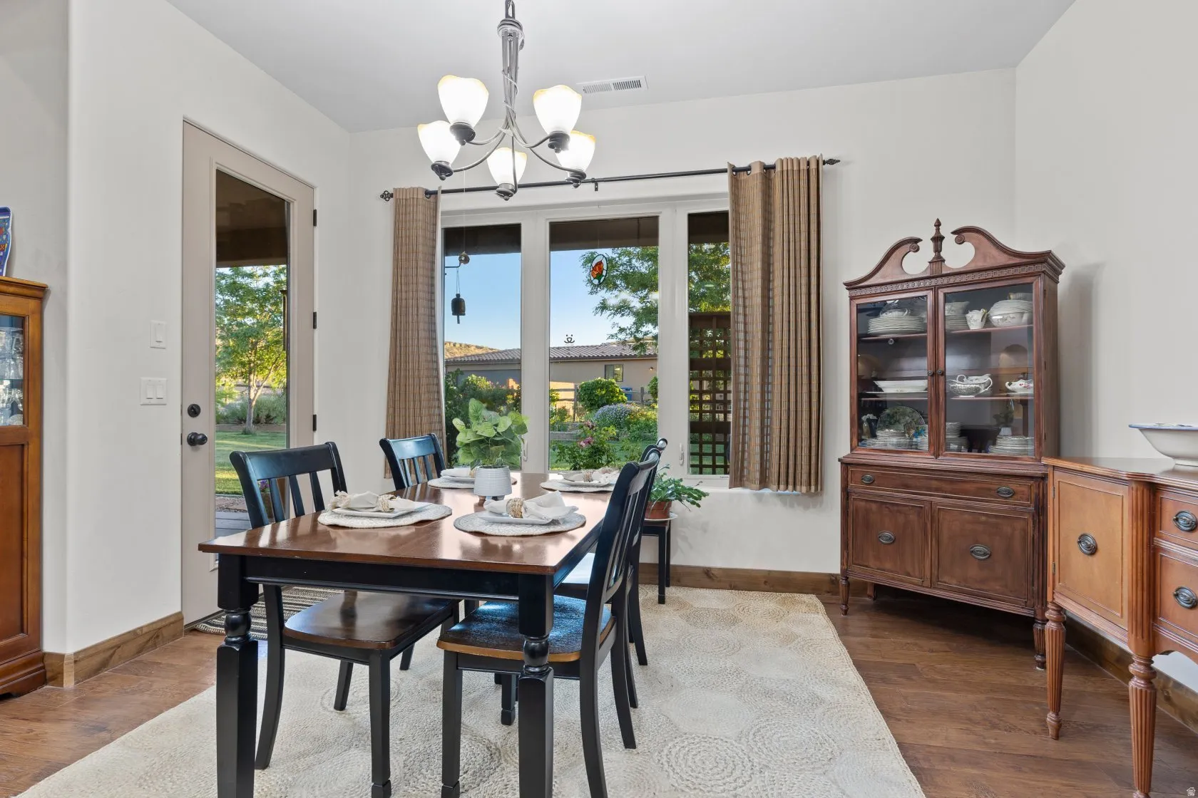 Dining area featuring wood-finish flooring, a contemporary chandelier, and a glass-paneled exterior door