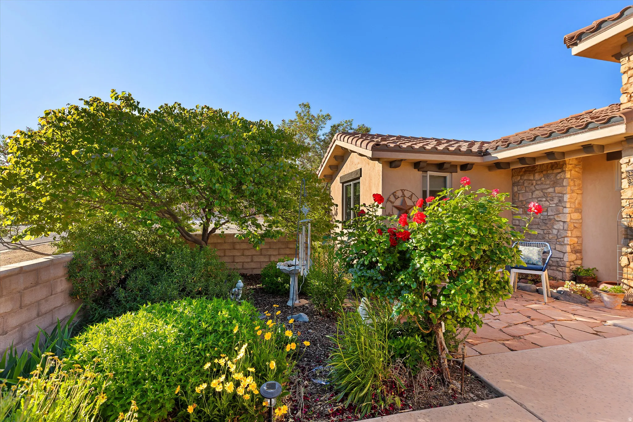 Front exterior featuring stucco finish, stone veneer accents, and a red tile roof