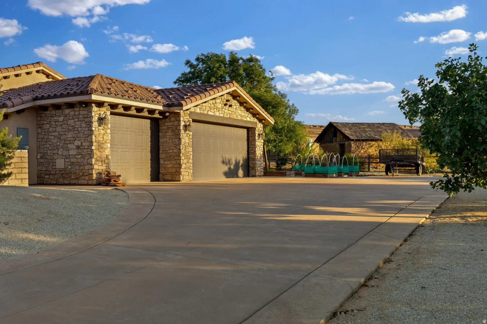 Stone-clad two-car garage with a tile roof and sconce lighting