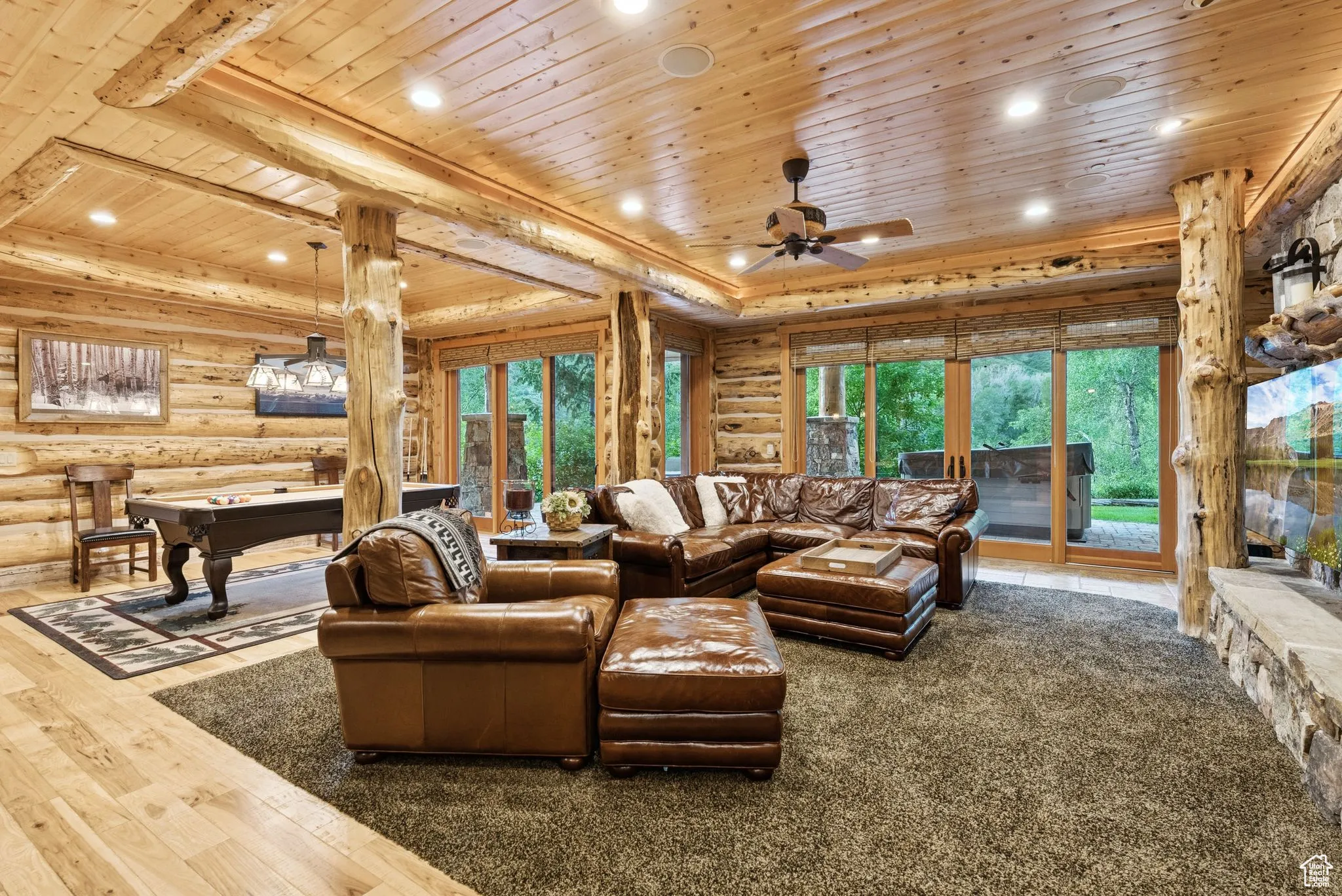 Living area featuring tongue-in-groove ceiling, rustic walls, recessed lighting, ceiling fan, and wood flooring