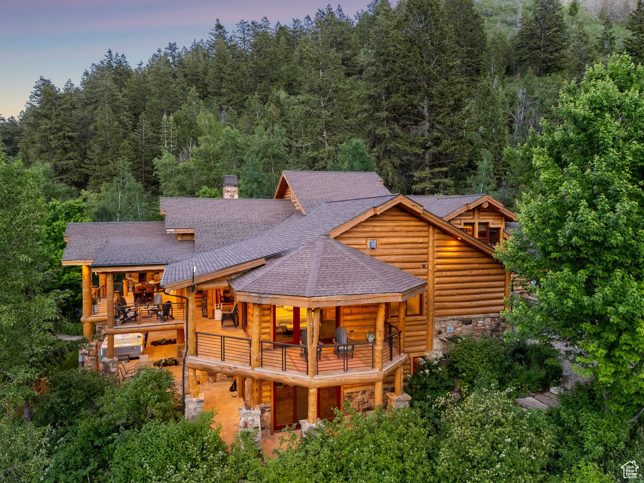 Back of property with a balcony, a shingled roof, stone siding, a chimney, and split-log veneer, framed home