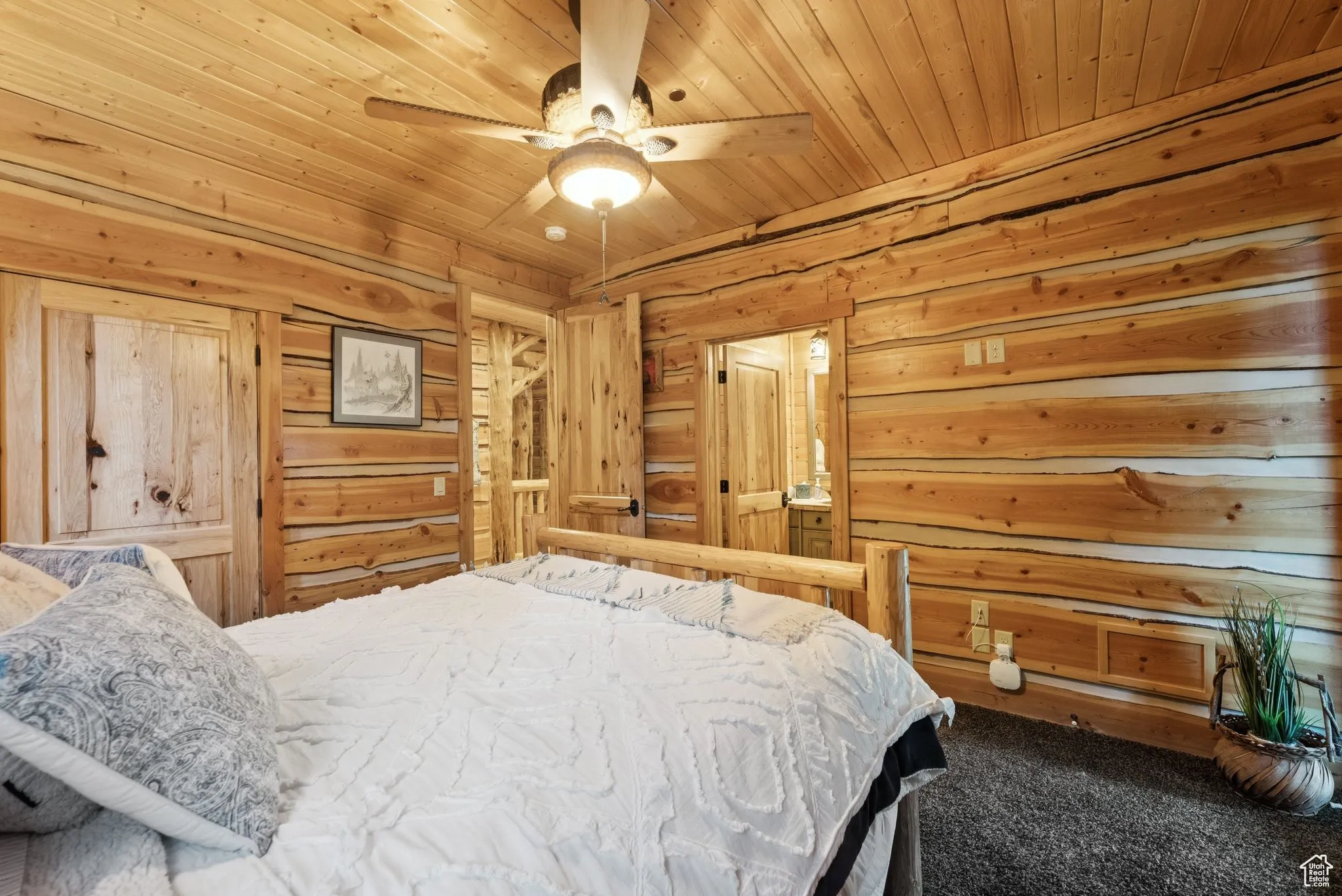 Carpeted bedroom with wood walls, tongue-in-groove ceiling, and ceiling fan