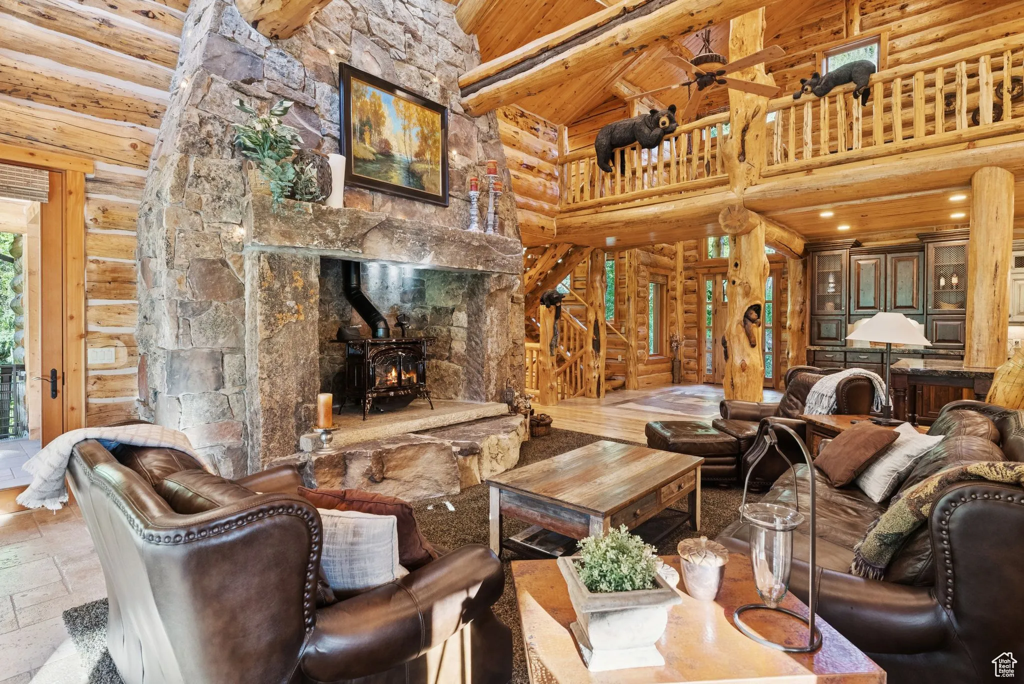 Living area with high vaulted ceiling, rustic walls, a wood stove, stone tile flooring, and tongue-in-groove ceiling