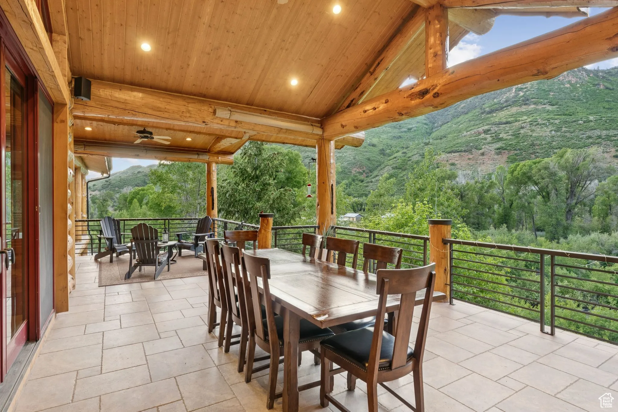 View of patio featuring outdoor dining area, a mountain view, and a view of trees