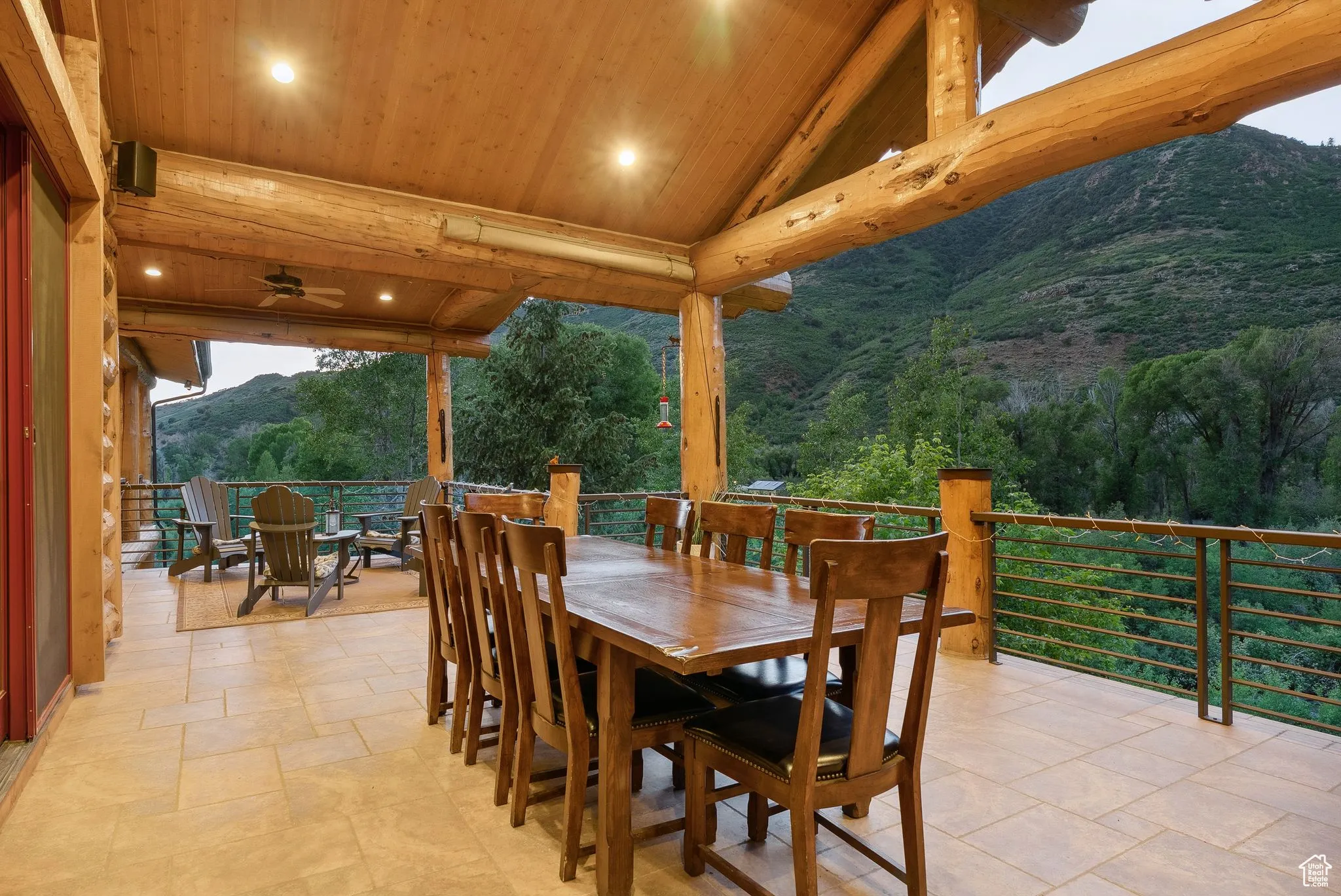 View of patio with outdoor dining space, a mountain view, ceiling fan, and a serene view