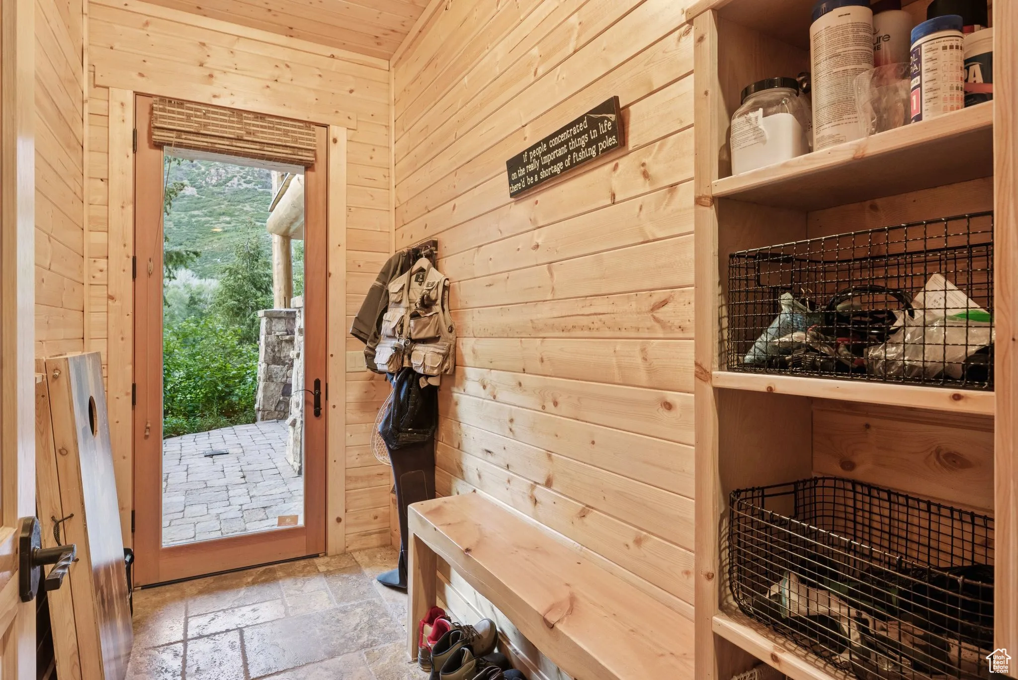Mudroom with wood walls and stone tile floors