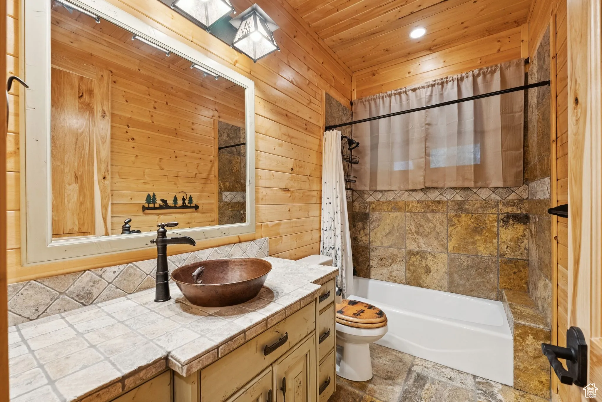 Full bathroom featuring vanity, tongue-in-groove ceiling, backsplash, shower / tub combo, and wood walls
