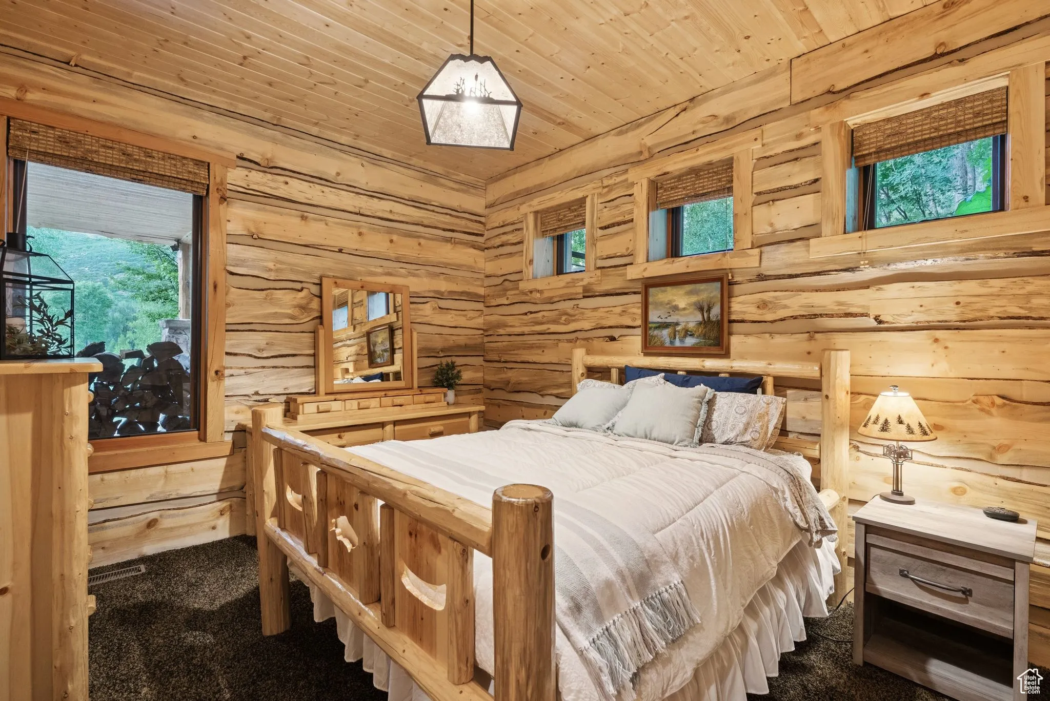 Bedroom featuring dark carpet, tongue-in-groove ceiling, and rustic walls