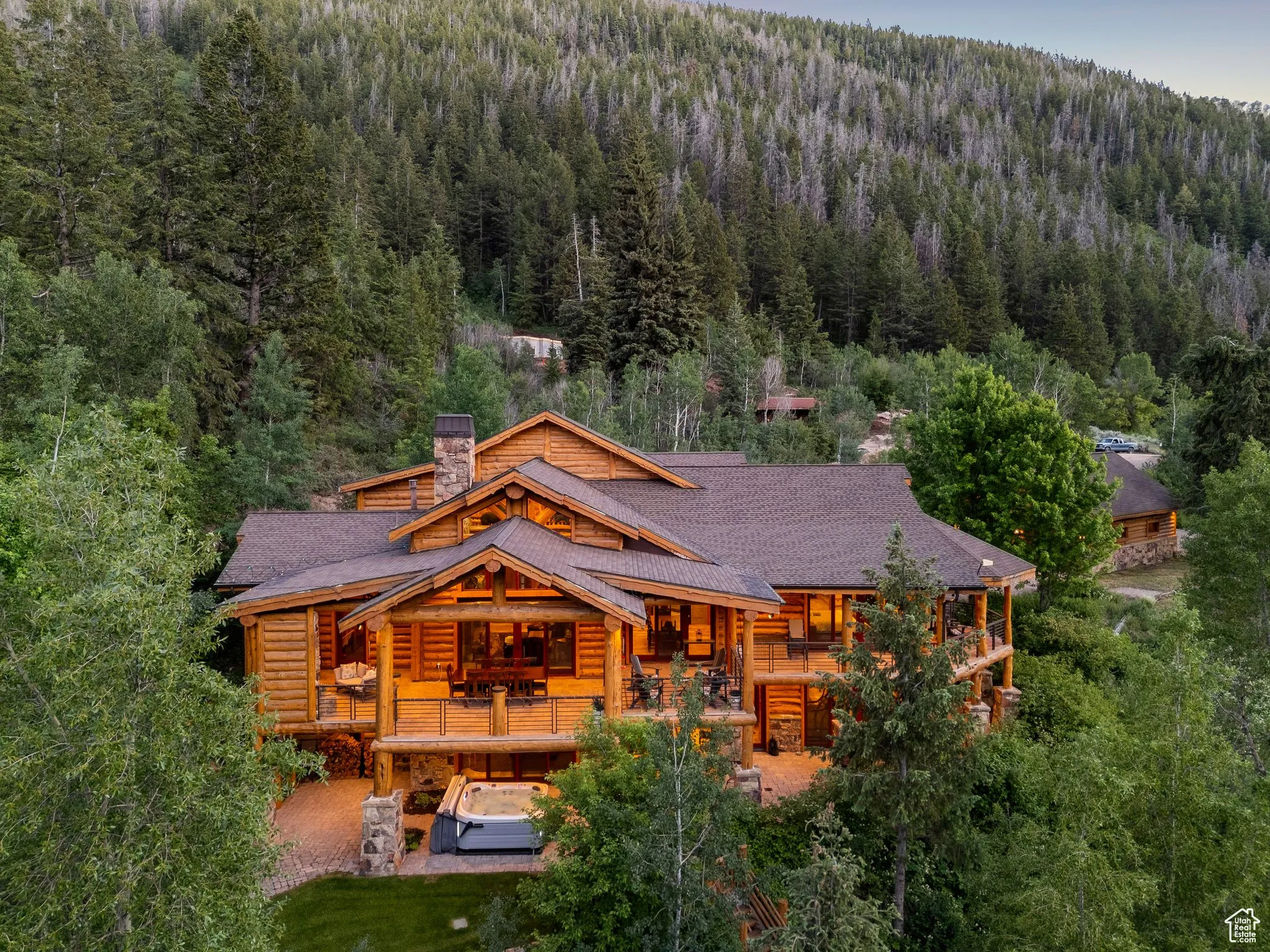 Back of property with a wooded view, split-log veneer, framed home a chimney, and a shingled roof