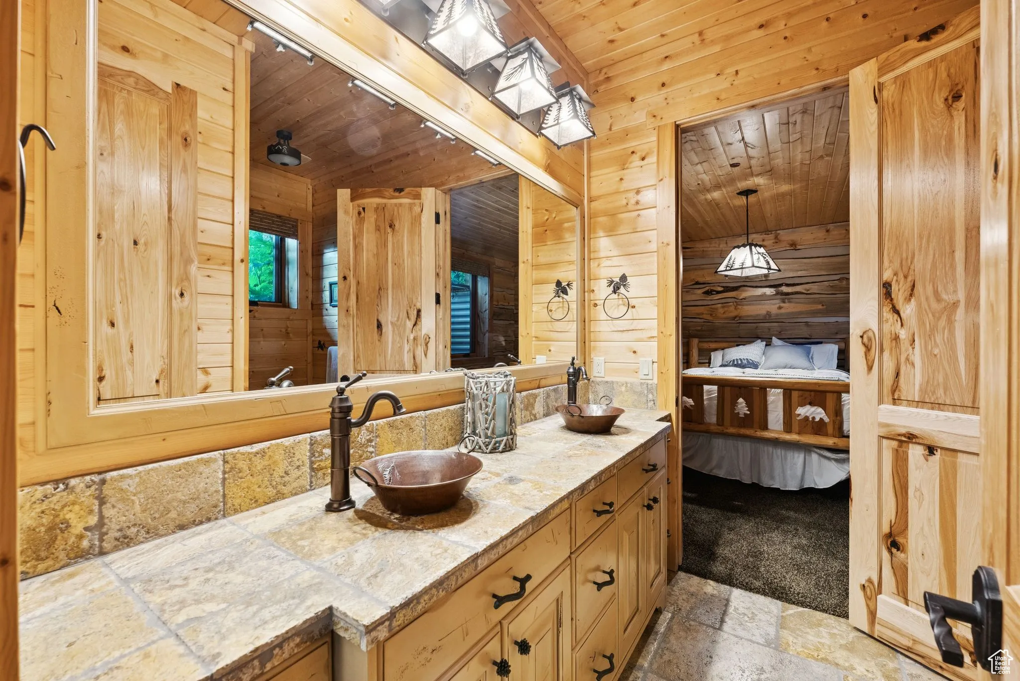 Full bathroom featuring stone tile floors, double vanity, tongue-in-groove ceiling, wooden walls, and ensuite bathroom