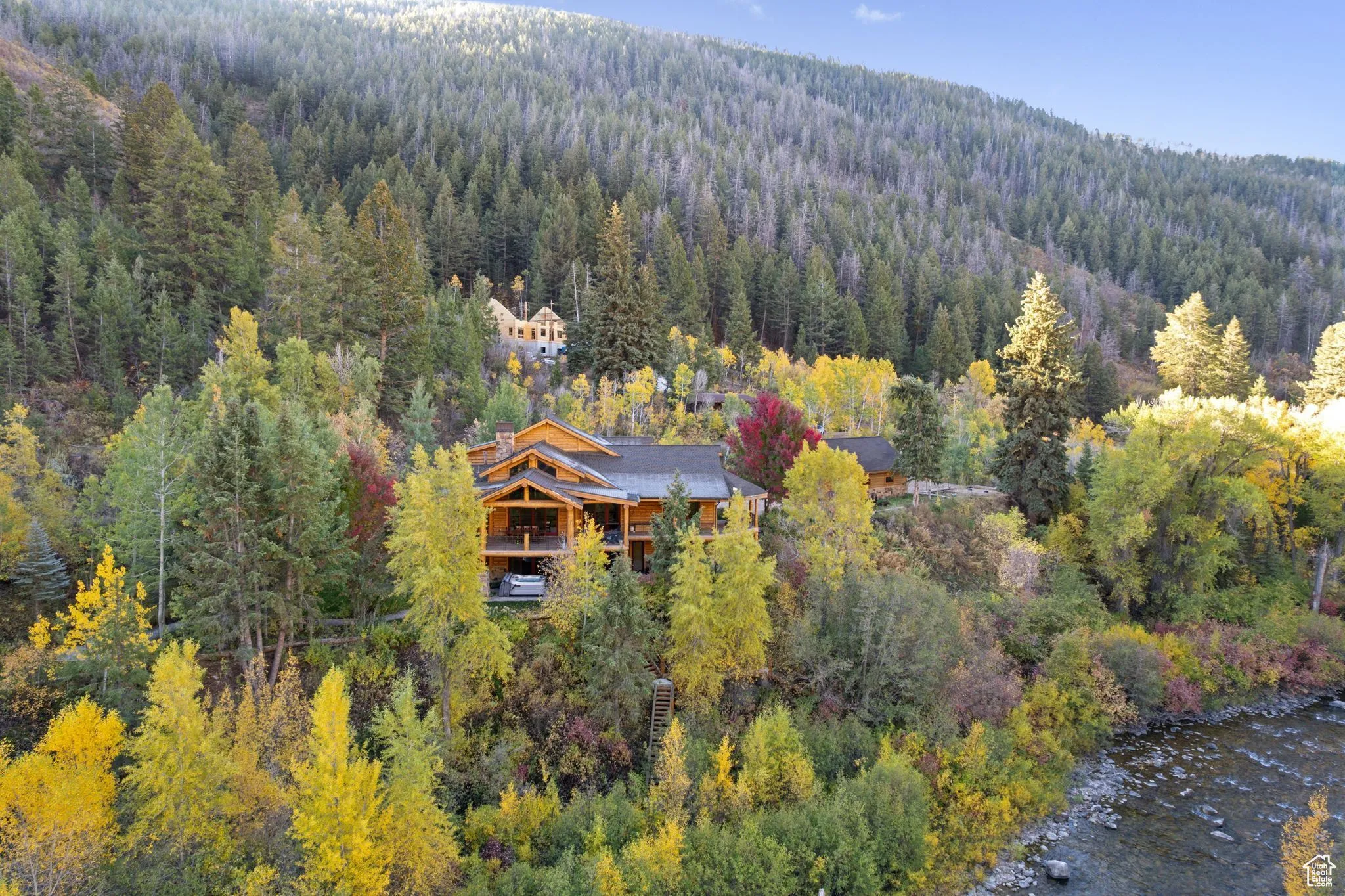 View from above of property with a heavily wooded area and a large body of water