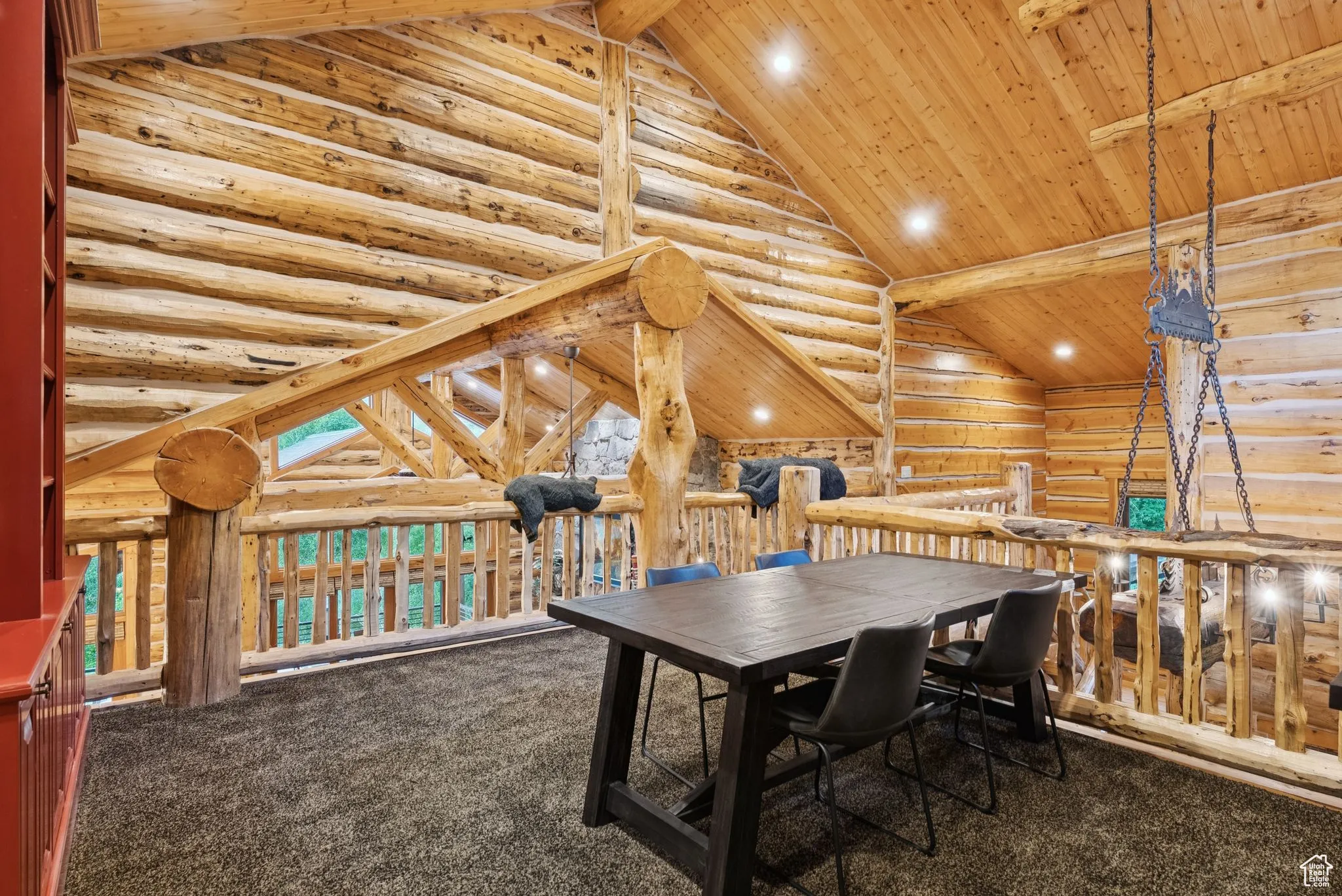 Carpeted home office loft with a tongue-in-groove ceiling with exposed beams, high vaulted ceiling, split-log walls, and recessed lighting