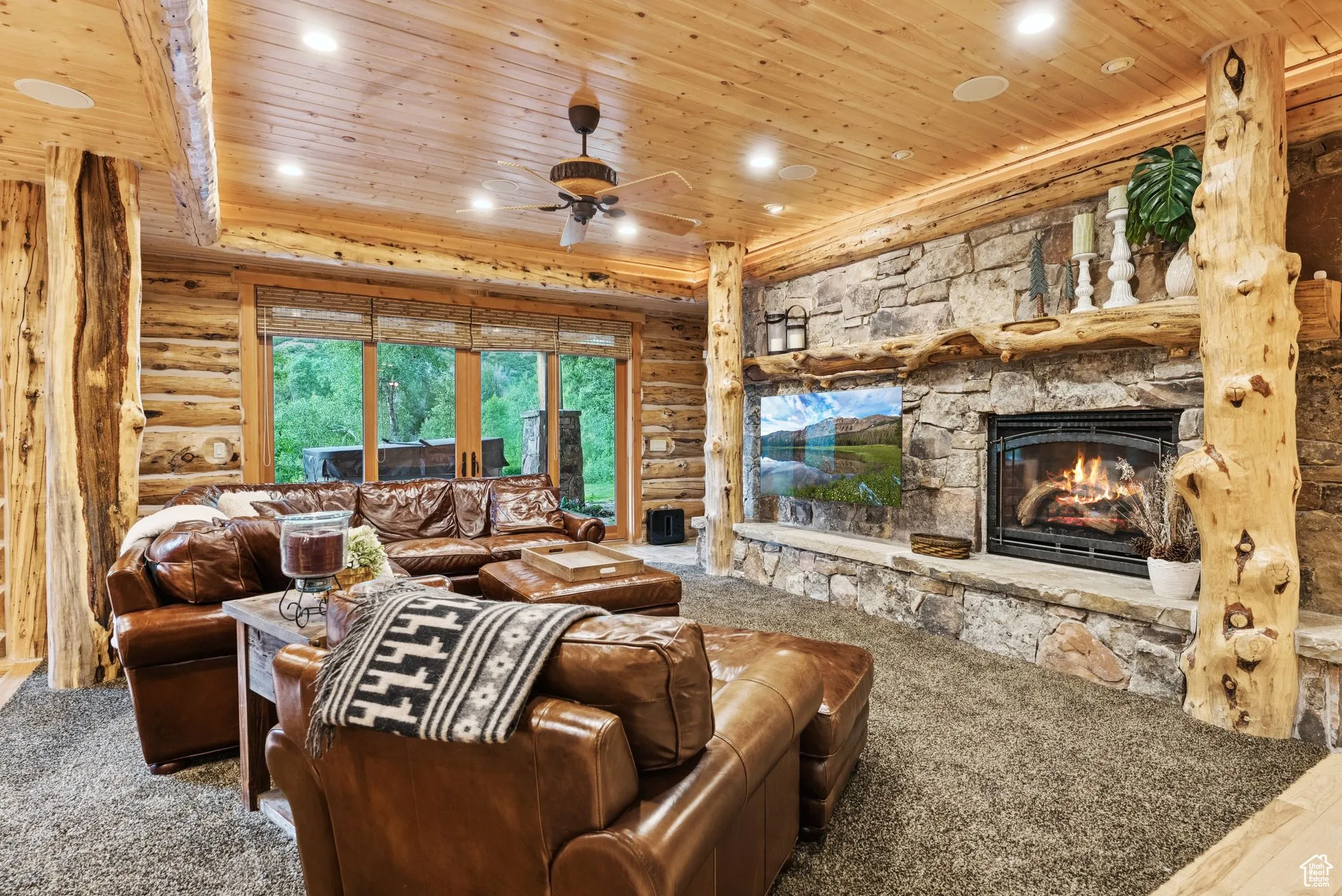Living room featuring tongue-in-groove ceiling, split-log walls, a propane fireplace, ceiling fan, and recessed lighting