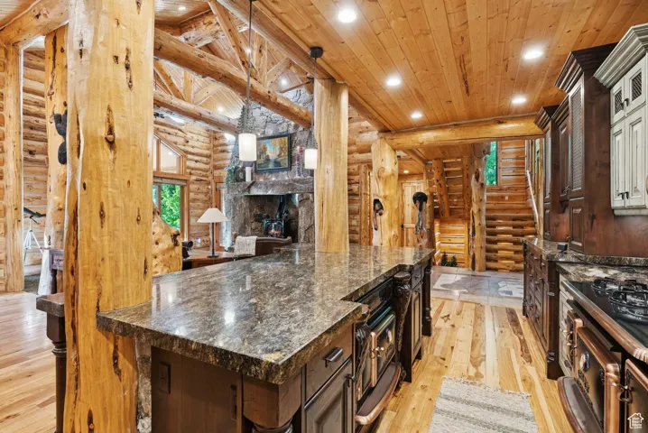 Kitchen featuring log walls, tongue-in-groove ceiling, light wood-style flooring, recessed lighting, and dark brown cabinetry