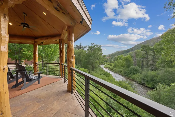 Balcony featuring a serene mountain view and ceiling fan.