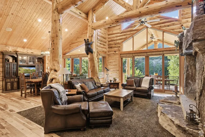 Living area featuring high vaulted ceiling, french doors, a tongue-in-groove ceiling with exposed beams, recessed lighting, and ceiling fan