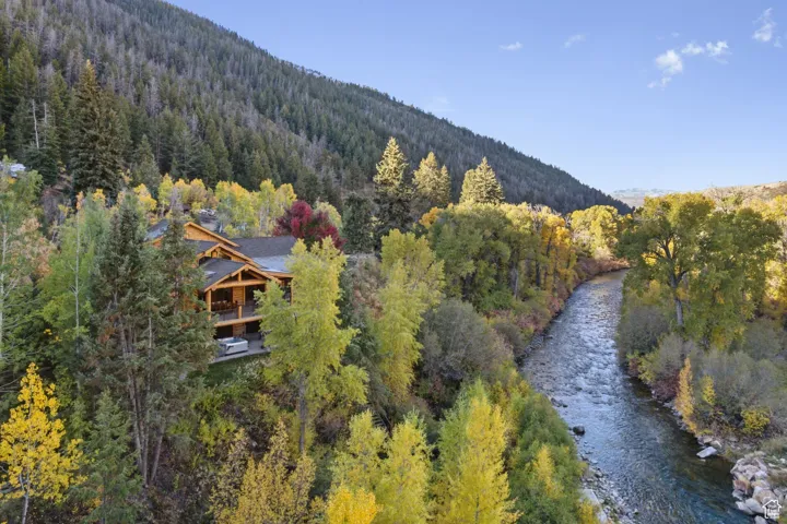 Aerial view of a heavily wooded area and a water and mountain view