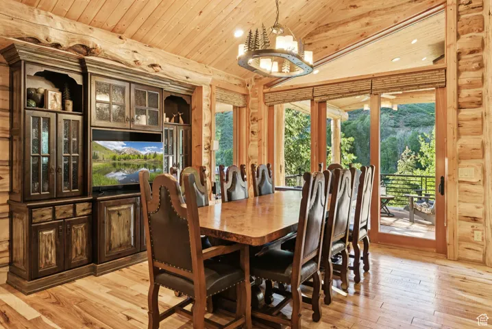 Dining room featuring tongue-in-groove ceiling, light wood flooring, healthy amount of natural light, a chandelier, and vaulted ceiling