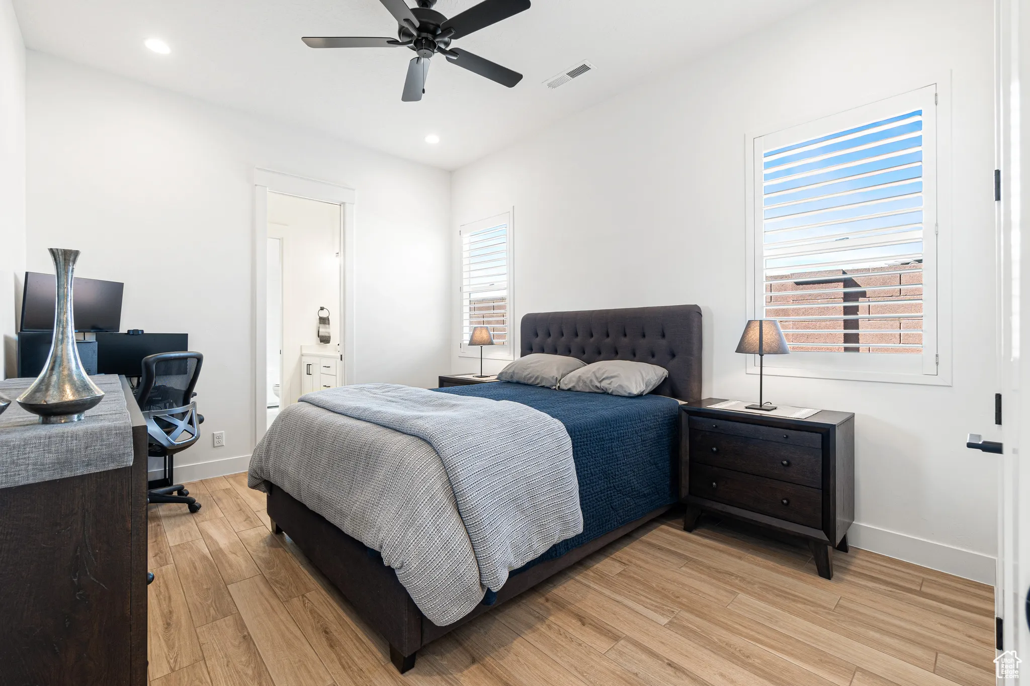 Bedroom with light wood-style floors, recessed lighting, a desk, connected bathroom, and ceiling fan