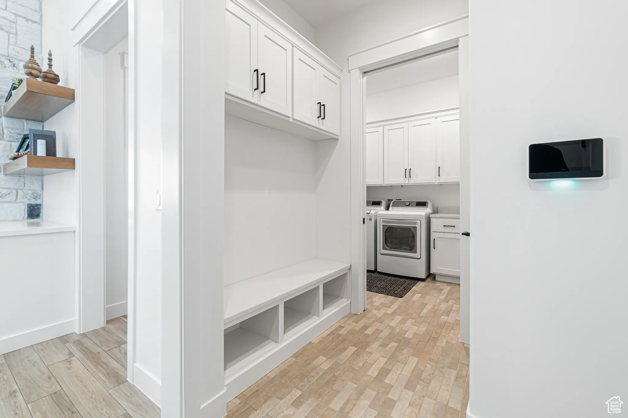 Mudroom with light wood-style floors and washing machine and dryer