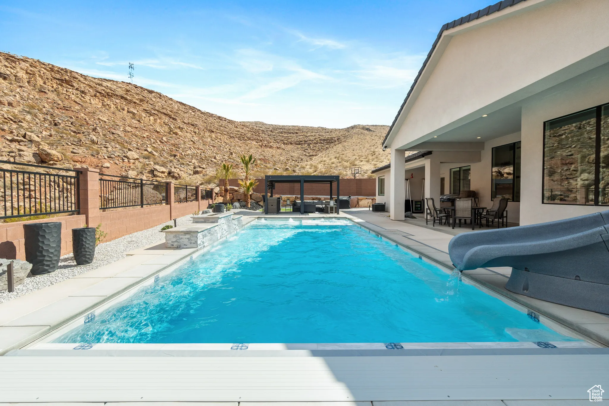 View of swimming pool featuring a water slide, a mountain view, an outdoor hangout area, a fenced backyard, and a patio