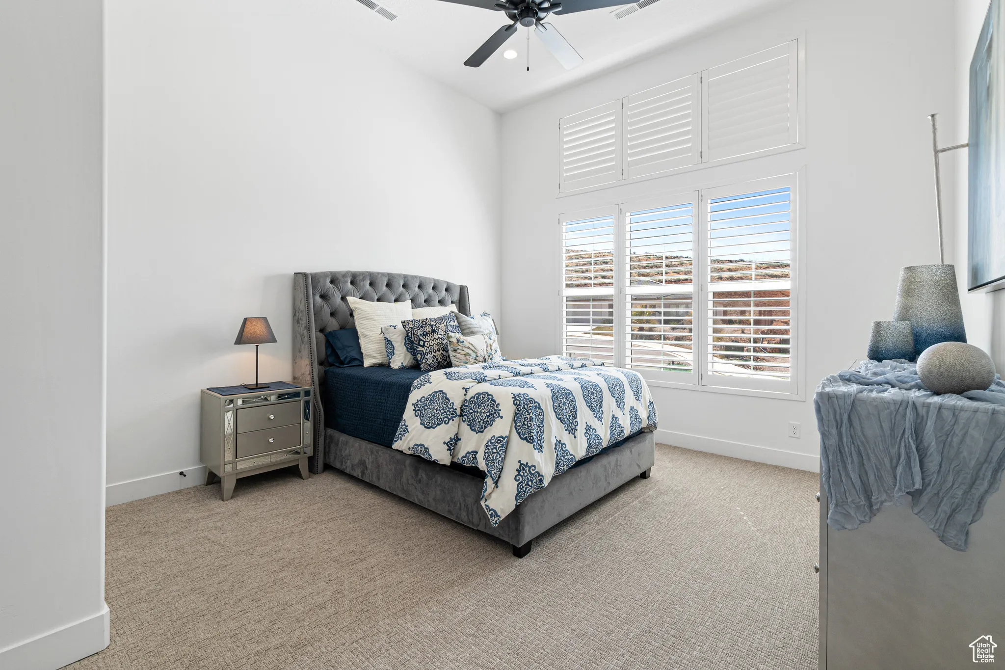 Carpeted bedroom featuring baseboards and a ceiling fan