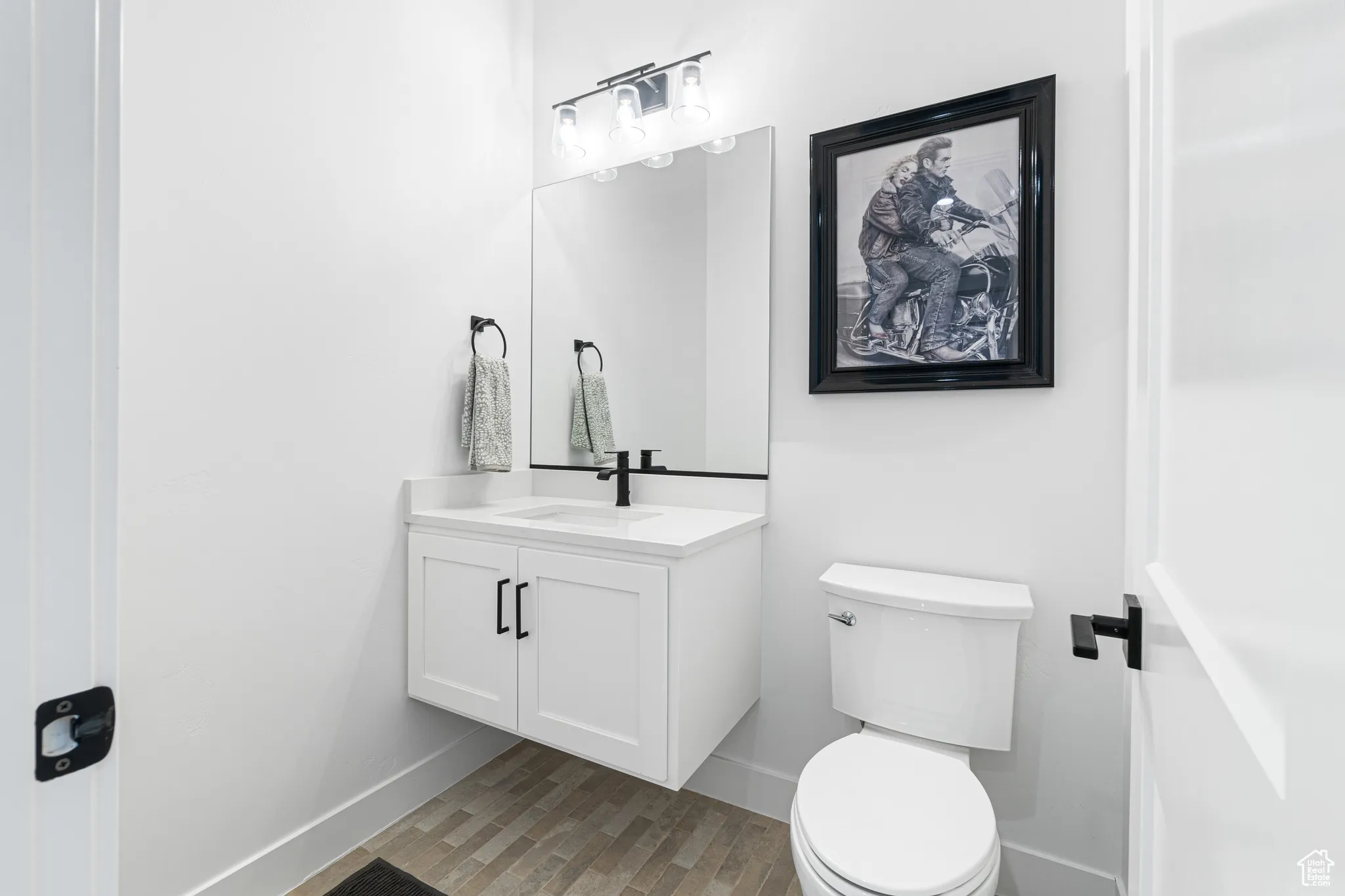 Half bathroom with vanity and wood finished floors